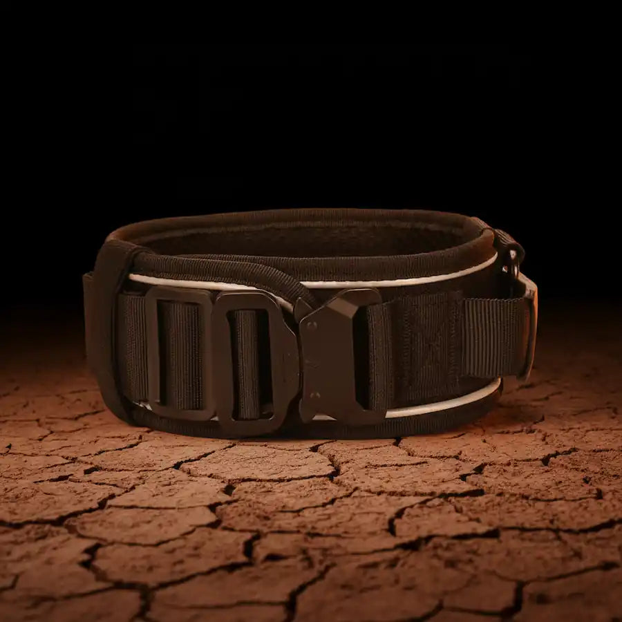 Black tactical dog collar with quick-release buckle and reflective strip on cracked red outback clay, Red Dirt Dogs Australia